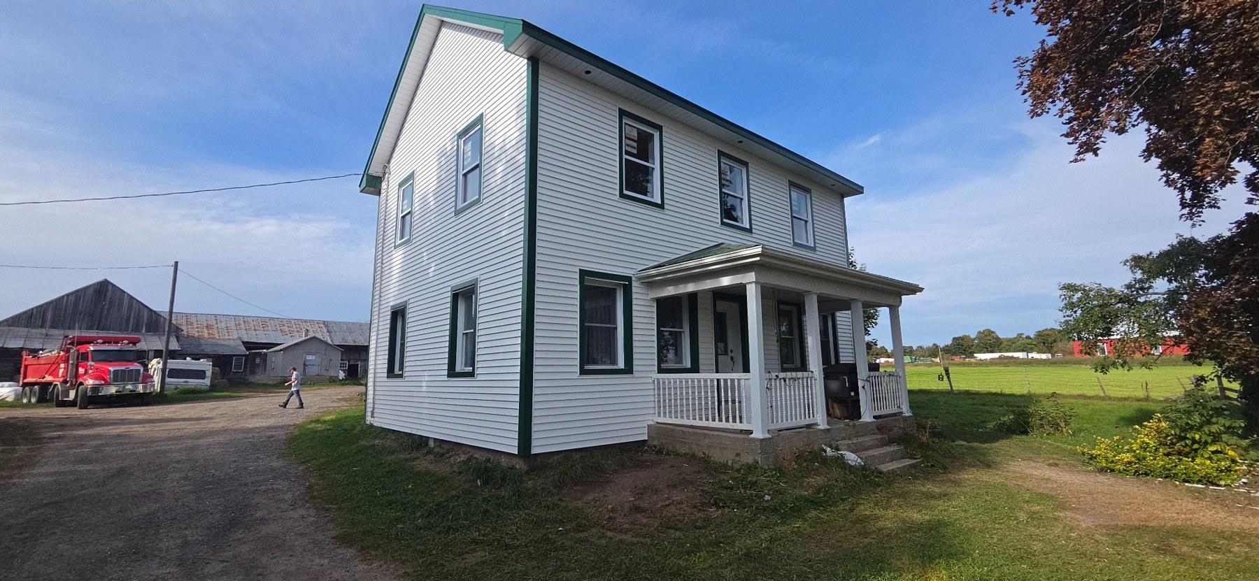 Projet Coffey : vue en angle de la maison avec son nouvel étage et son revêtement extérieur blanc