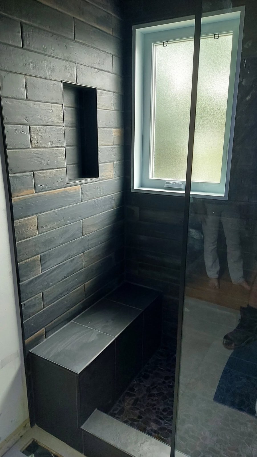 Douche avec système Schluter et pierres rondes